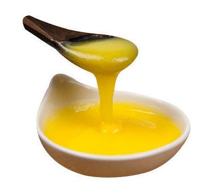 A spoon full of Ghee lifted from a bowl full of Cow Ghee